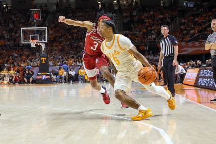 Feb 28, 2023; Knoxville, Tennessee, USA; Tennessee Volunteers guard Zakai Zeigler (5) moves the ball against Arkansas Razorbacks guard Nick Smith Jr. (3) during the first half at Thompson-Boling Arena. Mandatory Credit: Randy Sartin-USA TODAY Sports