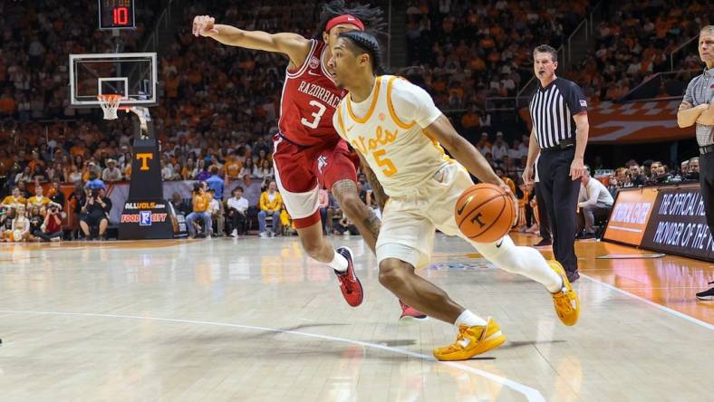 Feb 28, 2023; Knoxville, Tennessee, USA; Tennessee Volunteers guard Zakai Zeigler (5) moves the ball against Arkansas Razorbacks guard Nick Smith Jr. (3) during the first half at Thompson-Boling Arena. Mandatory Credit: Randy Sartin-USA TODAY Sports