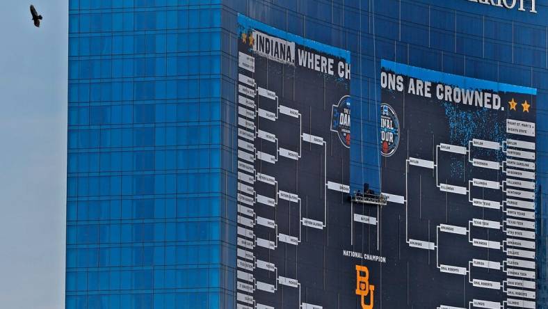 A bird gets an aerial view as the giant March Madness basketball bracket sign begins to come down Tuesday, April 6, 2021 off the J.W. Marriott in downtown Indianapolis, after March Madness and Final Four finished.

With March Madness And Final Four Finished Signage Comes Down