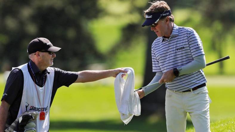 Brett Quigley cleans off his club with help from his caddy during the first round of the Bridgestone Senior Players Championship at Firestone Country Club on Thursday, June 24, 2021, in Akron, Ohio.

Bridgestone24 9