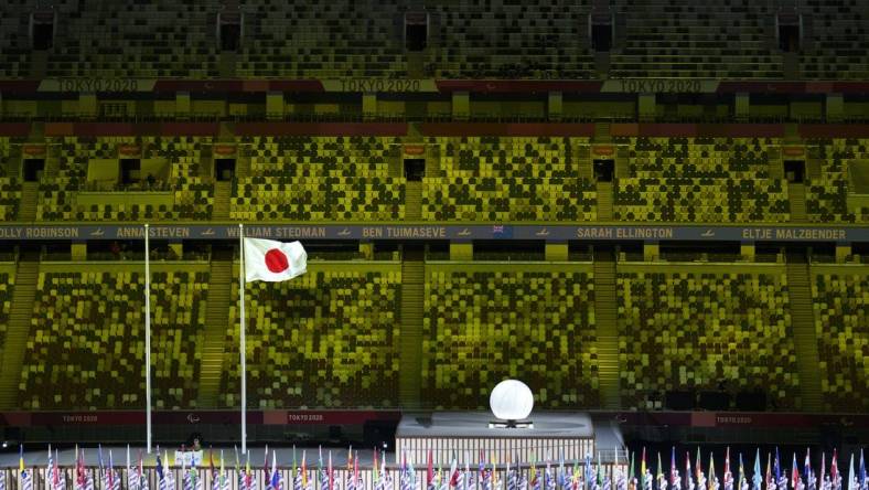 Aug 24, 2021; Tokyo, Japan; Athlete's Parade Assistants holding flags of the competing countries in front of the Protocol Stage during the Athlete's Parade at the Opening Ceremony of the Tokyo 2020 Paralympic Games.  Mandatory Credit: Bob Martin/OIS Handout Photo via USA TODAY Sports