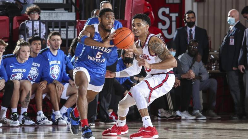 Nov 23, 2021; Queens, New York, USA;  St. Francis Terriers guard Larry Moreno (5) looks to make a pass as he is guarded by St. John   s Red Storm guard Tareq Coburn (10) at Carnesecca Arena. Mandatory Credit: Wendell Cruz-USA TODAY Sports