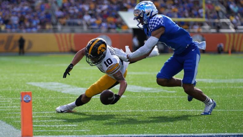 Jan 1, 2022; Orlando, FL, USA; Iowa Hawkeyes wide receiver Arland Bruce IV (10) is unable to make a catch while defended by Kentucky Wildcats safety Vito Tisdale (7) during first half in the 2022 Citrus Bowl at Camping World Stadium. Mandatory Credit: Jasen Vinlove-USA TODAY Sports