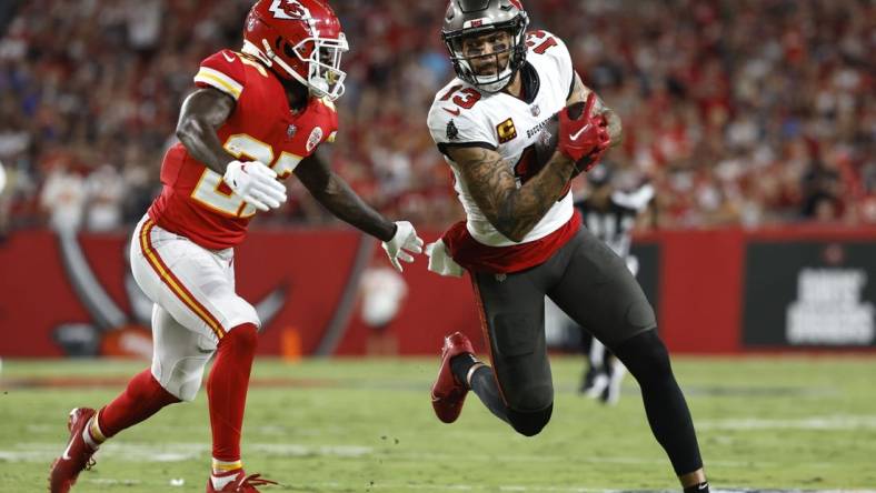 Oct 2, 2022; Tampa, Florida, USA; Tampa Bay Buccaneers wide receiver Mike Evans (13) runs with the ball as Kansas City Chiefs cornerback Rashad Fenton (27) defends during the first half at Raymond James Stadium. Mandatory Credit: Kim Klement-USA TODAY Sports