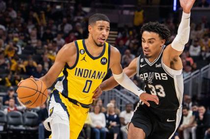 Oct 21, 2022; Indianapolis, Indiana, USA; Indiana Pacers guard Tyrese Haliburton (0) dribbles the ball while San Antonio Spurs guard Tre Jones (33) defends  in the second half at Gainbridge Fieldhouse. Mandatory Credit: Trevor Ruszkowski-USA TODAY Sports