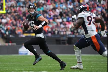 Oct 30, 2022; London, United Kingdom;  Jacksonville Jaguars quarterback Trevor Lawrence (16) throws the ball in the first half against under pressure from Denver Broncos defensive end Dre'Mont Jones (93) during an NFL International Series game at Wembley Stadium. Mandatory Credit: Kirby Lee-USA TODAY Sports