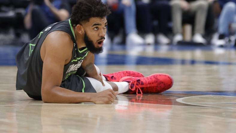 Nov 28, 2022; Washington, District of Columbia, USA; Minnesota Timberwolves center Karl-Anthony Towns (32) holds his leg after being injured against the Washington Wizards in the third quarter at Capital One Arena. Mandatory Credit: Geoff Burke-USA TODAY Sports