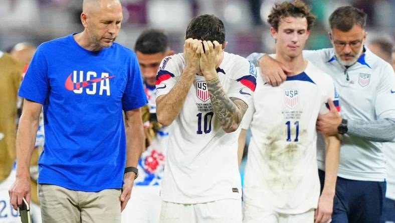 Dec 3, 2022; Al Rayyan, Qatar; United States of America manager Gregg Berhalter and forward Christian Pulisic (10) and midfielder Brenden Aaronson (11) react after losing a round of sixteen match against the Netherlands in the 2022 FIFA World Cup at Khalifa International Stadium. Mandatory Credit: Danielle Parhizkaran-USA TODAY Sports