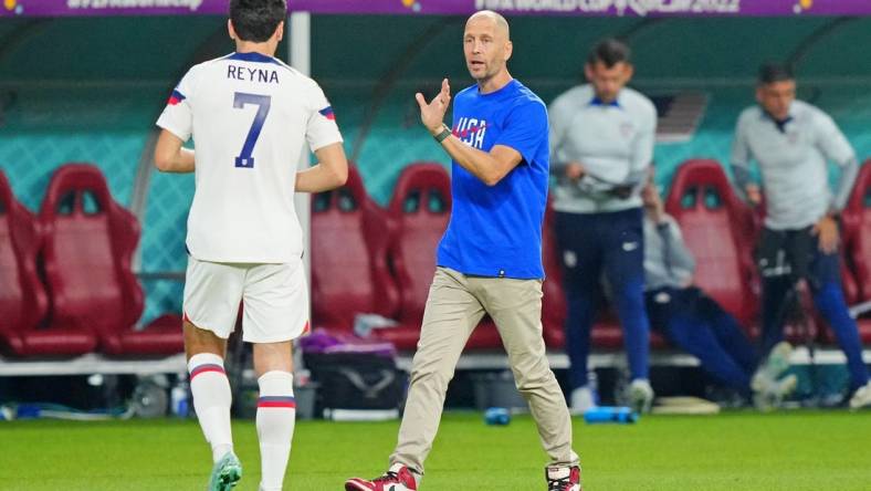 Dec 3, 2022; Al Rayyan, Qatar; United States of America manager Gregg Berhalter talks with midfielder Giovanni Reyna (7) against the Netherlands during the second half of a round of sixteen match in the 2022 FIFA World Cup at Khalifa International Stadium. Mandatory Credit: Danielle Parhizkaran-USA TODAY Sports