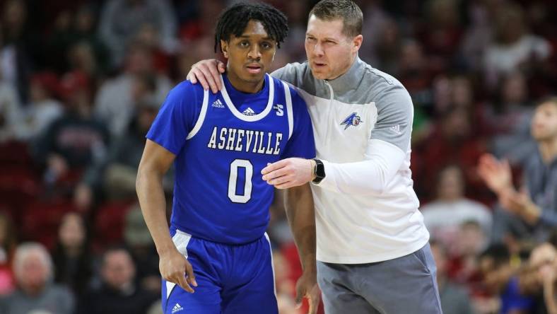 Dec 21, 2022; Fayetteville, Arkansas, USA; UNC Asheville Bulldogs guard Trent Stephney (0) talks to head coach Mike Morrell during the first half against the Arkansas Razorbacks at Bud Walton Arena. Mandatory Credit: Nelson Chenault-USA TODAY Sports