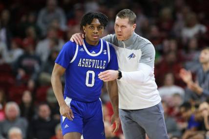 Dec 21, 2022; Fayetteville, Arkansas, USA; UNC Asheville Bulldogs guard Trent Stephney (0) talks to head coach Mike Morrell during the first half against the Arkansas Razorbacks at Bud Walton Arena. Mandatory Credit: Nelson Chenault-USA TODAY Sports