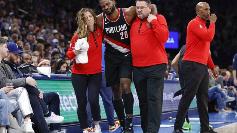 Dec 21, 2022; Oklahoma City, Oklahoma, USA; Portland Trail Blazers forward Justise Winslow (26) is helped off the court after a leg injury during the second half against the Oklahoma City Thunder at Paycom Center. Oklahoma City won 101-98. Mandatory Credit: Alonzo Adams-USA TODAY Sports