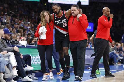 Dec 21, 2022; Oklahoma City, Oklahoma, USA; Portland Trail Blazers forward Justise Winslow (26) is helped off the court after a leg injury during the second half against the Oklahoma City Thunder at Paycom Center. Oklahoma City won 101-98. Mandatory Credit: Alonzo Adams-USA TODAY Sports