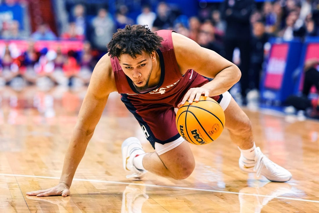 Dec 22, 2022; Lawrence, Kansas, USA; Harvard Crimson forward Chris Ledlum (4) slips while dribbling the ball during the first half against the Kansas Jayhawks at Allen Fieldhouse. Mandatory Credit: Jay Biggerstaff-USA TODAY Sports