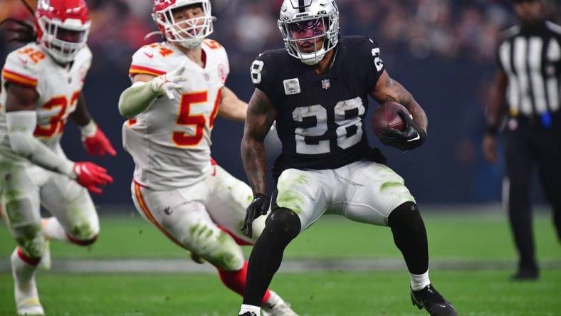 Jan 7, 2023; Paradise, Nevada, USA; Las Vegas Raiders running back Josh Jacobs (28) runs the ball against the Kansas City Chiefs during the second half at Allegiant Stadium. Mandatory Credit: Gary A. Vasquez-USA TODAY Sports