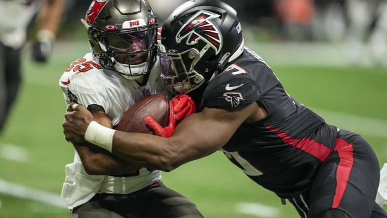 Jan 8, 2023; Atlanta, Georgia, USA; Tampa Bay Buccaneers running back Giovani Bernard (25) is tackled by Atlanta Falcons linebacker Lorenzo Carter (9) during the second half at Mercedes-Benz Stadium. Mandatory Credit: Dale Zanine-USA TODAY Sports