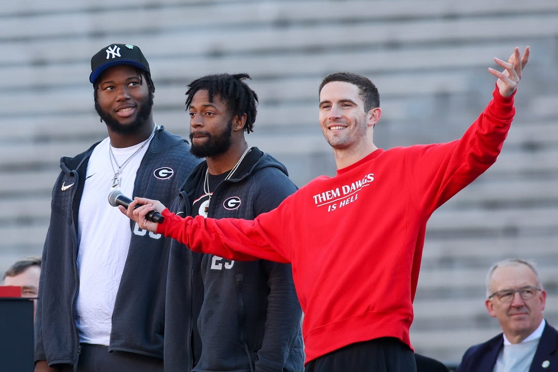 Jan 14, 2023; Athens, GA, USA; Georgia Bulldogs offensive lineman Sedrick Van Pran (63) and defensive back Christopher Smith (29) and quarterback Stetson Bennett (13) speak at the national championship celebration at Sanford Stadium. Mandatory Credit: Brett Davis-USA TODAY Sports