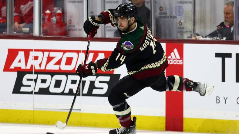 Jan 17, 2023; Tempe, Arizona, USA; Arizona Coyotes defenseman Shayne Gostisbehere (14) passes the puck against the Detroit Red Wings in the first period at Mullett Arena. Mandatory Credit: Mark J. Rebilas-USA TODAY Sports