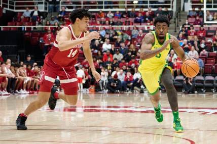 Jan 21, 2023; Stanford, California, USA; Oregon Ducks guard Jermaine Couisnard (5) drives against Stanford Cardinal forward Spencer Jones (14) during the second half at Maples Pavilion. Mandatory Credit: Robert Edwards-USA TODAY Sports