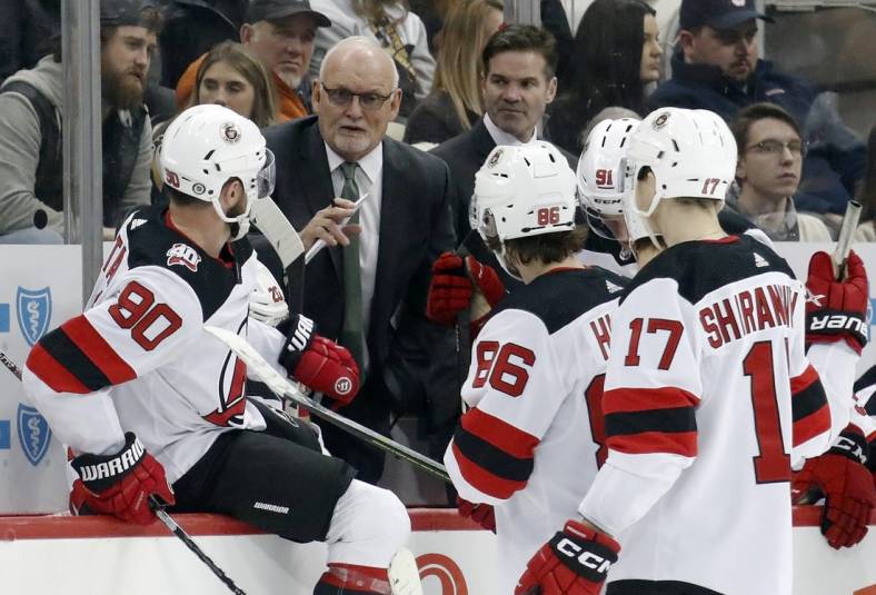Feb 18, 2023; Pittsburgh, Pennsylvania, USA;  New Jersey Devils head coach Lindy Ruff (second from left) talks to his team during a time-out against the Pittsburgh Penguins in the third period at PPG Paints Arena. The Devils won 5-2.  Mandatory Credit: Charles LeClaire-USA TODAY Sports