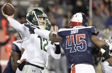 Feb 18, 2023; Houston, TX, USA; Orlando Guardians quarterback Quinten Dormady (12) throws a pass against Houston Roughnecks linebacker John Dana (45) in the fourth quarter at TDECU Stadium. Mandatory Credit: Thomas Shea-USA TODAY Sports