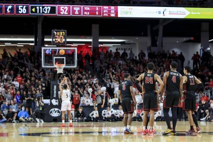 Feb 22, 2023; Cincinnati, Ohio, USA;  Members of the Temple Owls stand on the court as Cincinnati Bearcats guard David DeJulius (5) shoots a technical free throw in the second half at Fifth Third Arena. Mandatory Credit: Aaron Doster-USA TODAY Sports
