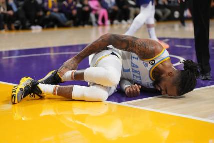 Feb 23, 2023; Los Angeles, California, USA; Los Angeles Lakers guard D'Angelo Russell (1) reacts after suffering a right ankle sprain after the game in the first half at Crypto.com Arena. Mandatory Credit: Kirby Lee-USA TODAY Sports