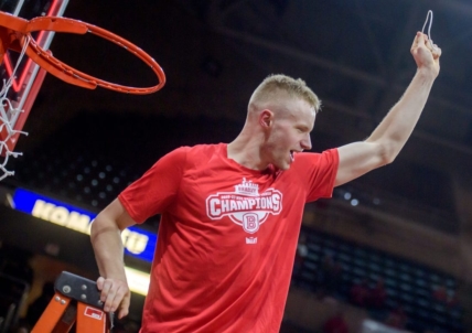 Bradley's Rienk Mast holds up a piece of net he cut in celebration of the Braves' MVC championship after defeating Drake 73-61on Sunday, Feb. 26, 2023 at Carver Arena.