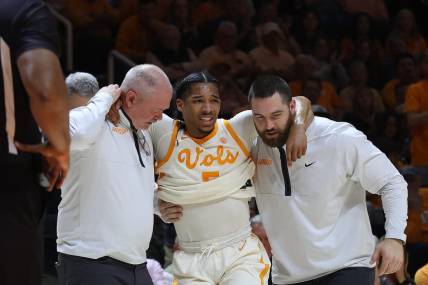 Feb 28, 2023; Knoxville, Tennessee, USA; Tennessee Volunteers guard Zakai Zeigler (5) is helped off the court after an injury during the first half against the Arkansas Razorbacks at Thompson-Boling Arena. Mandatory Credit: Randy Sartin-USA TODAY Sports