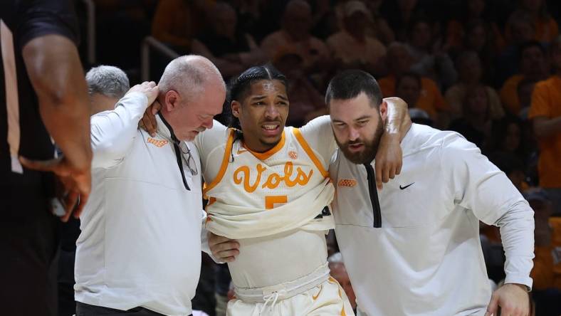 Feb 28, 2023; Knoxville, Tennessee, USA; Tennessee Volunteers guard Zakai Zeigler (5) is helped off the court after an injury during the first half against the Arkansas Razorbacks at Thompson-Boling Arena. Mandatory Credit: Randy Sartin-USA TODAY Sports