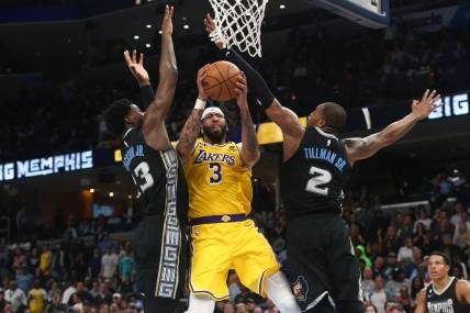 Feb 28, 2023; Memphis, Tennessee, USA; Los Angeles Lakers forward Anthony Davis (3) drives to the basket between Memphis Grizzlies forward Jaren Jackson Jr. (13) and forward Brandon Clark (15) during the second half at FedExForum. Mandatory Credit: Petre Thomas-USA TODAY Sports