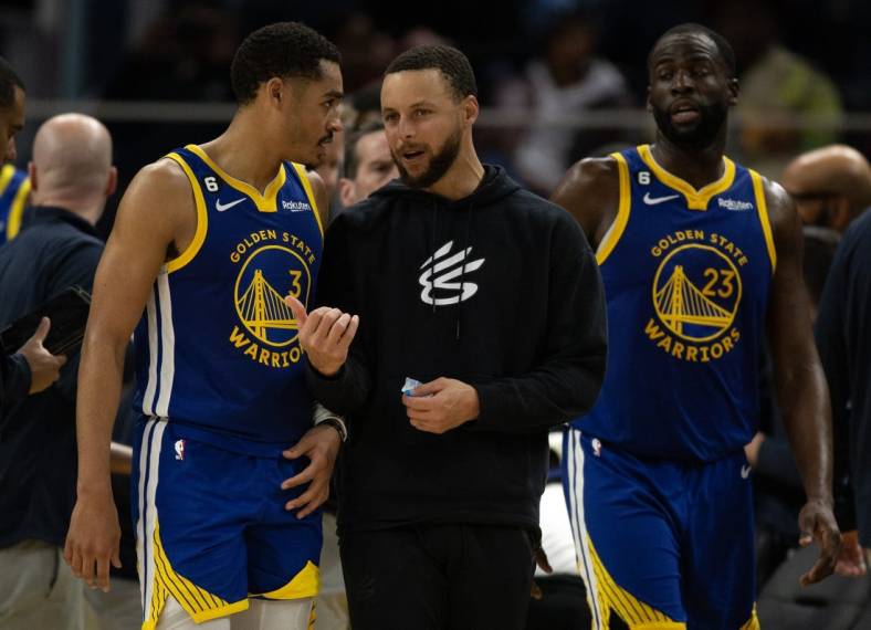 Feb 28, 2023; San Francisco, California, USA; Golden State Warriors guard Jordan Poole (3) confers with injured teammate Stephen Curry during a timeout in the fourth quarter against the Portland Trail Blazers at Chase Center. Mandatory Credit: D. Ross Cameron-USA TODAY Sports