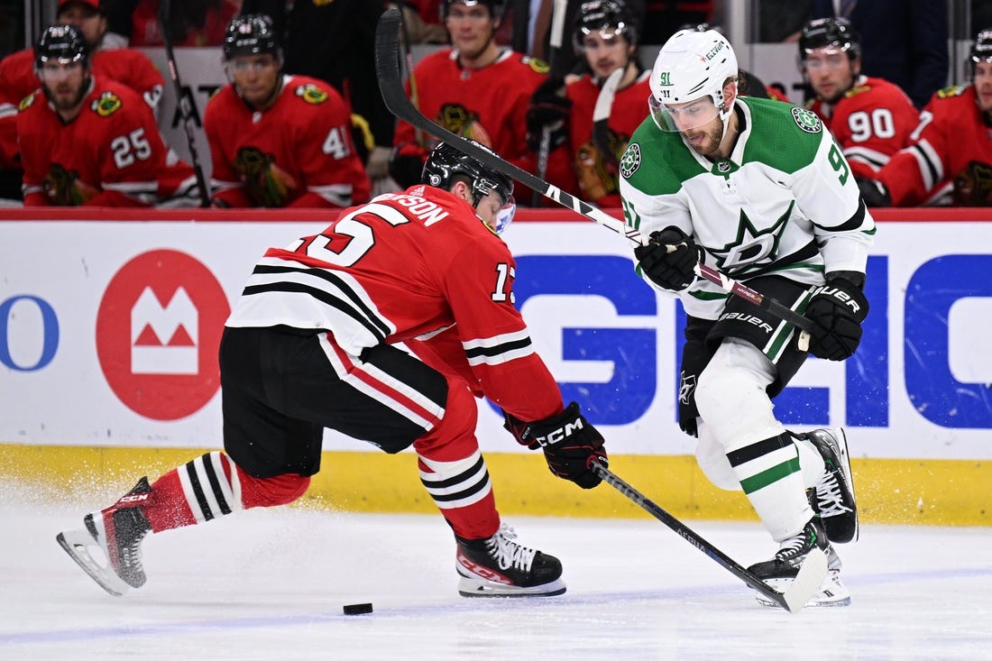 Mar 2, 2023; Chicago, Illinois, USA;  Dallas Stars forward Tyler Seguin (91) dekes around Chicago Blackhawks forward Joey Anderson (15) in the second period at United Center. Mandatory Credit: Jamie Sabau-USA TODAY Sports