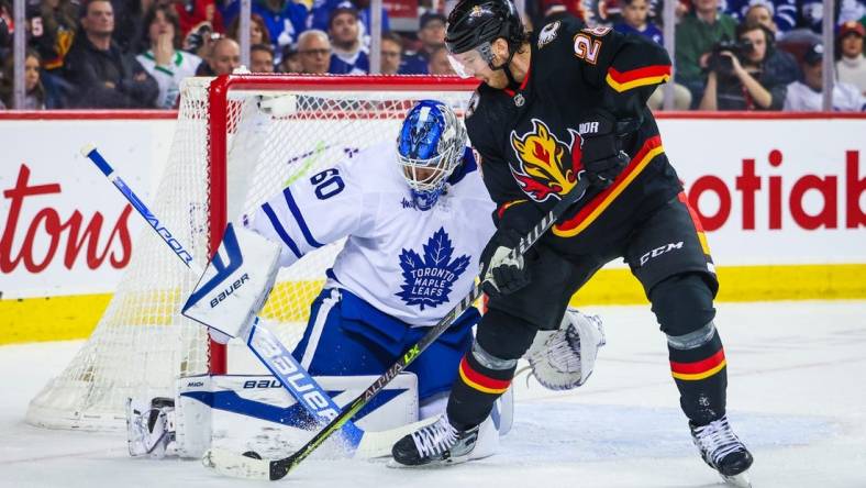 Mar 2, 2023; Calgary, Alberta, CAN; Toronto Maple Leafs goaltender Joseph Woll (60) makes a save against Calgary Flames center Elias Lindholm (28) during the second period at Scotiabank Saddledome. Mandatory Credit: Sergei Belski-USA TODAY Sports