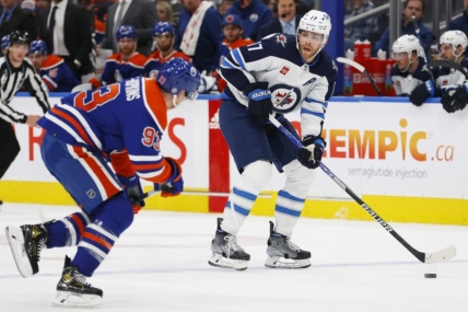 Mar 3, 2023; Edmonton, Alberta, CAN; Winnipeg Jets forward Adam Lowry (17) looks to make a pass against Edmonton Oilers forward Ryan Nugent-Hopkins (93) during the second period at Rogers Place. Mandatory Credit: Perry Nelson-USA TODAY Sports