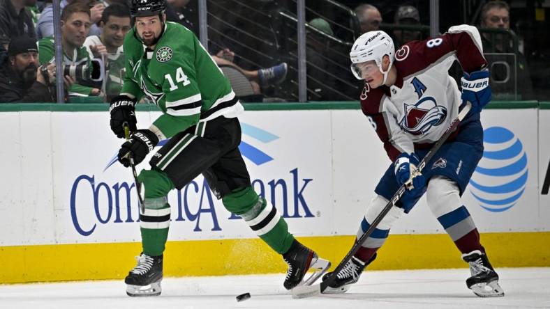 Mar 4, 2023; Dallas, Texas, USA; Dallas Stars left wing Jamie Benn (14) passes the puck in front of Colorado Avalanche defenseman Cale Makar (8) during the first period at the American Airlines Center. Mandatory Credit: Jerome Miron-USA TODAY Sports