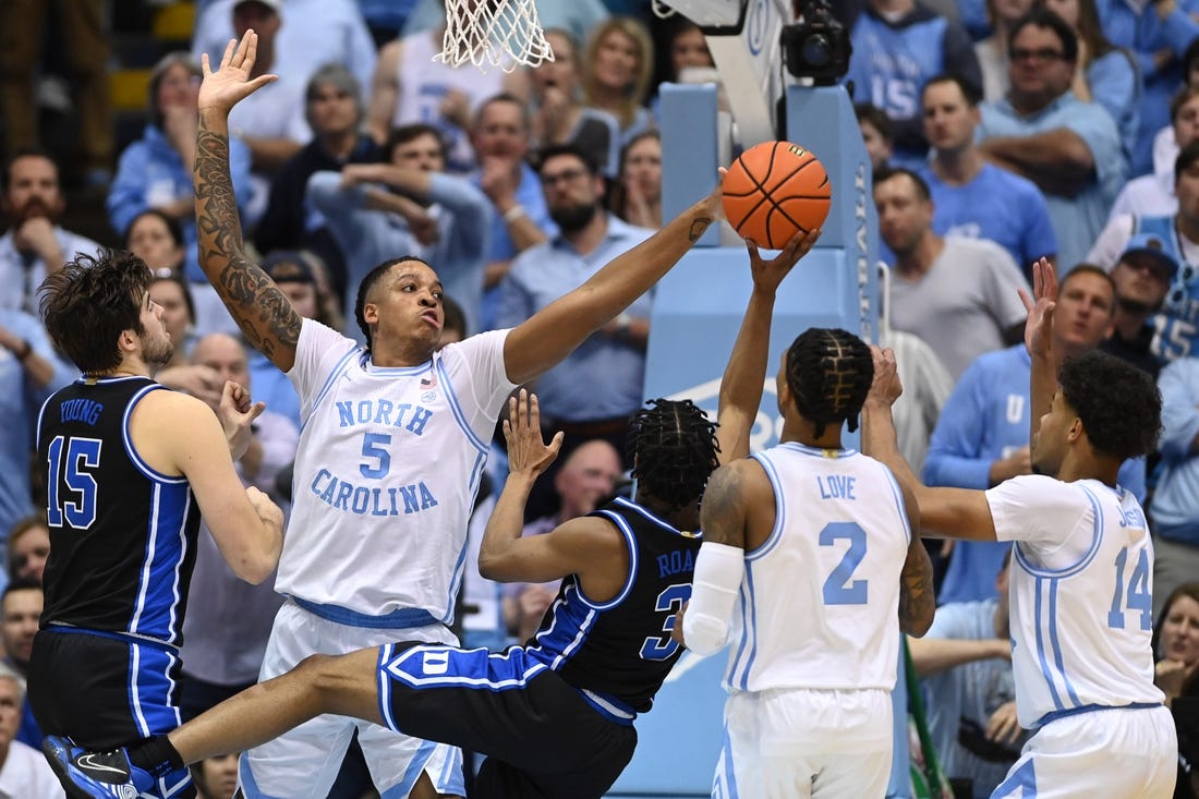 Mar 4, 2023; Chapel Hill, North Carolina, USA;  Duke Blue Devils guard Jeremy Roach (3) shoots as North Carolina Tar Heels forward Armando Bacot (5) and guard Caleb Love (2) and forward Puff Johnson (14) defend in the second half at Dean E. Smith Center. Mandatory Credit: Bob Donnan-USA TODAY Sports