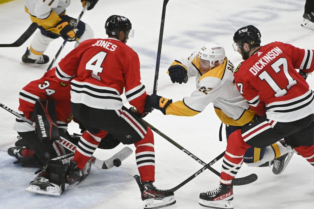 Mar 4, 2023; Chicago, Illinois, USA; Nashville Predators defenseman Tyson Barrie (22) tries to score against Chicago Blackhawks defenseman Seth Jones (4) and Chicago Blackhawks center Jason Dickinson (17) during the second period at the United Center. Mandatory Credit: Matt Marton-USA TODAY Sports