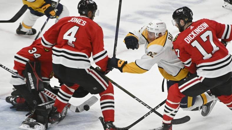 Mar 4, 2023; Chicago, Illinois, USA; Nashville Predators defenseman Tyson Barrie (22) tries to score against Chicago Blackhawks defenseman Seth Jones (4) and Chicago Blackhawks center Jason Dickinson (17) during the second period at the United Center. Mandatory Credit: Matt Marton-USA TODAY Sports