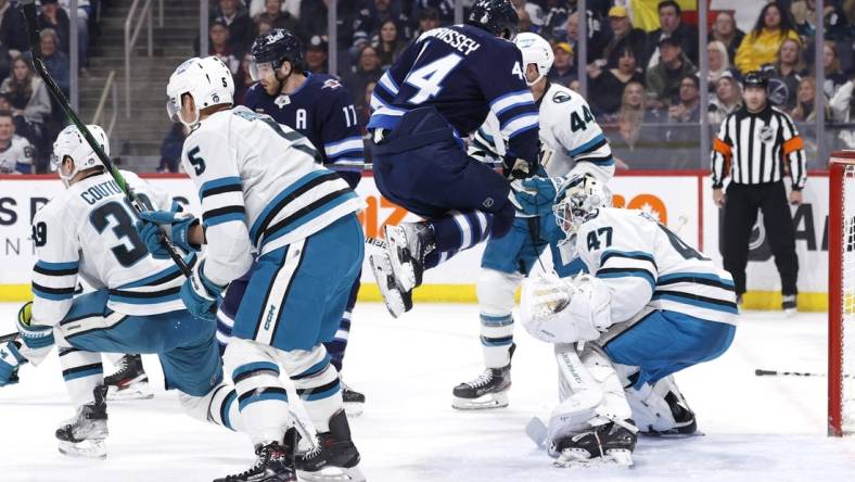 Mar 6, 2023; Winnipeg, Manitoba, CAN; Winnipeg Jets defenseman Josh Morrissey (44) leaps out of the way of a shot on San Jose Sharks goaltender James Reimer (47) in the second period at Canada Life Centre. Mandatory Credit: James Carey Lauder-USA TODAY Sports