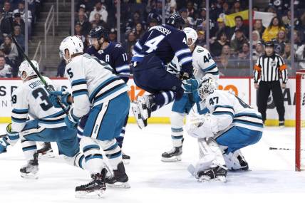 Mar 6, 2023; Winnipeg, Manitoba, CAN; Winnipeg Jets defenseman Josh Morrissey (44) leaps out of the way of a shot on San Jose Sharks goaltender James Reimer (47) in the second period at Canada Life Centre. Mandatory Credit: James Carey Lauder-USA TODAY Sports