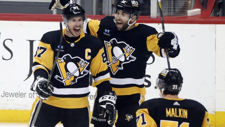 Mar 7, 2023; Pittsburgh, Pennsylvania, USA;  Pittsburgh Penguins center Sidney Crosby (87) reacts with left wing Jason Zucker (16) and center Evgeni Malkin (71) after scoring the game winning power play goal in overtime against the Columbus Blue Jackets at PPG Paints Arena. Pittsburgh won 5-4 in overtime. Mandatory Credit: Charles LeClaire-USA TODAY Sports