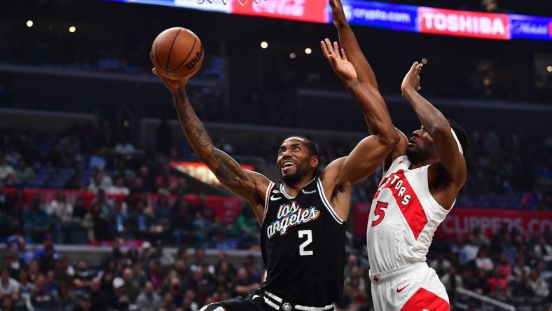 Mar 8, 2023; Los Angeles, California, USA; Los Angeles Clippers forward Kawhi Leonard (2) moves to the basket against Toronto Raptors forward Will Barton (5) during the first half at Crypto.com Arena. Mandatory Credit: Gary A. Vasquez-USA TODAY Sports