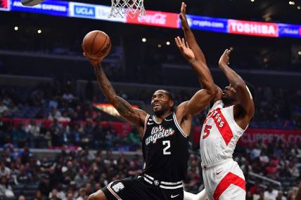 Mar 8, 2023; Los Angeles, California, USA; Los Angeles Clippers forward Kawhi Leonard (2) moves to the basket against Toronto Raptors forward Will Barton (5) during the first half at Crypto.com Arena. Mandatory Credit: Gary A. Vasquez-USA TODAY Sports