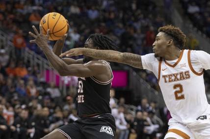Mar 9, 2023; Kansas City, MO, USA; Oklahoma State Cowboys guard John-Michael Wright (51) handles the ball while defended by Texas Longhorns guard Arterio Morris (2) in the first half at T-Mobile Center. Mandatory Credit: Amy Kontras-USA TODAY Sports