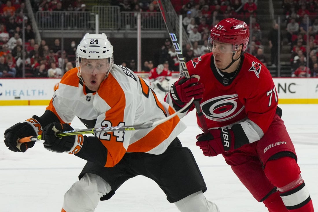 Mar 9, 2023; Raleigh, North Carolina, USA;  Carolina Hurricanes right wing Jesper Fast (71) and Philadelphia Flyers defenseman Nick Seeler (24) chase after the puck during the first period at PNC Arena. Mandatory Credit: James Guillory-USA TODAY Sports