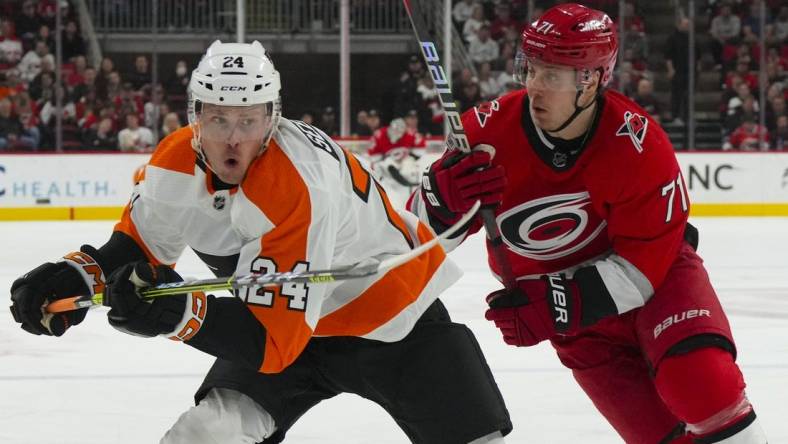 Mar 9, 2023; Raleigh, North Carolina, USA;  Carolina Hurricanes right wing Jesper Fast (71) and Philadelphia Flyers defenseman Nick Seeler (24) chase after the puck during the first period at PNC Arena. Mandatory Credit: James Guillory-USA TODAY Sports