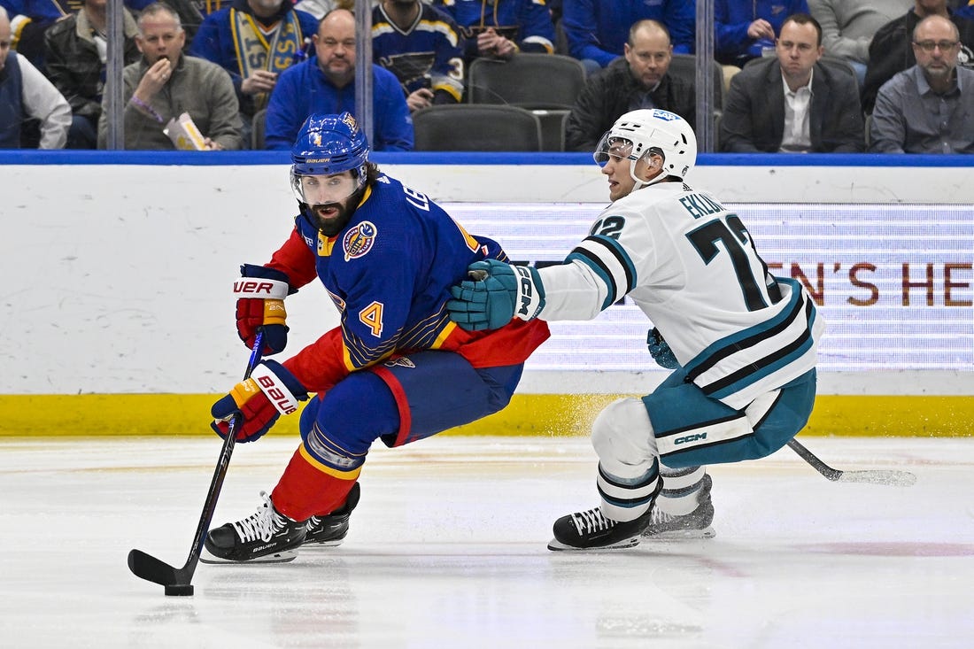 Mar 9, 2023; St. Louis, Missouri, USA;  St. Louis Blues defenseman Nick Leddy (4) controls the puck as San Jose Sharks left wing William Eklund (72) defends during the first period at Enterprise Center. Mandatory Credit: Jeff Curry-USA TODAY Sports