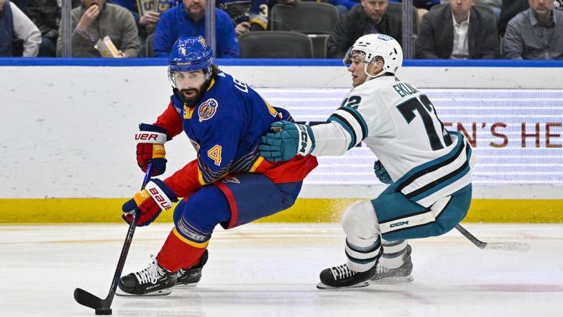 Mar 9, 2023; St. Louis, Missouri, USA;  St. Louis Blues defenseman Nick Leddy (4) controls the puck as San Jose Sharks left wing William Eklund (72) defends during the first period at Enterprise Center. Mandatory Credit: Jeff Curry-USA TODAY Sports