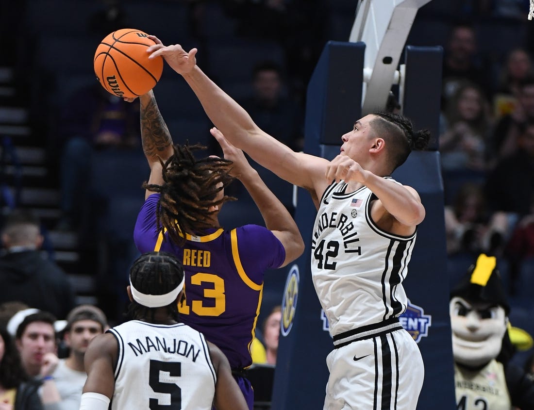 Mar 9, 2023; Nashville, TN, USA; Vanderbilt Commodores forward Quentin Millora-Brown (42) blocks a shot attempt by LSU Tigers forward Jalen Reed (13) during the first half at Bridgestone Arena. Mandatory Credit: Christopher Hanewinckel-USA TODAY Sports